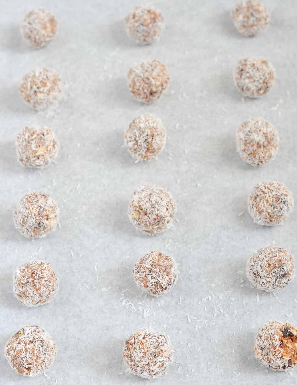 protein bliss balls are lined up after rolling in dry coconut