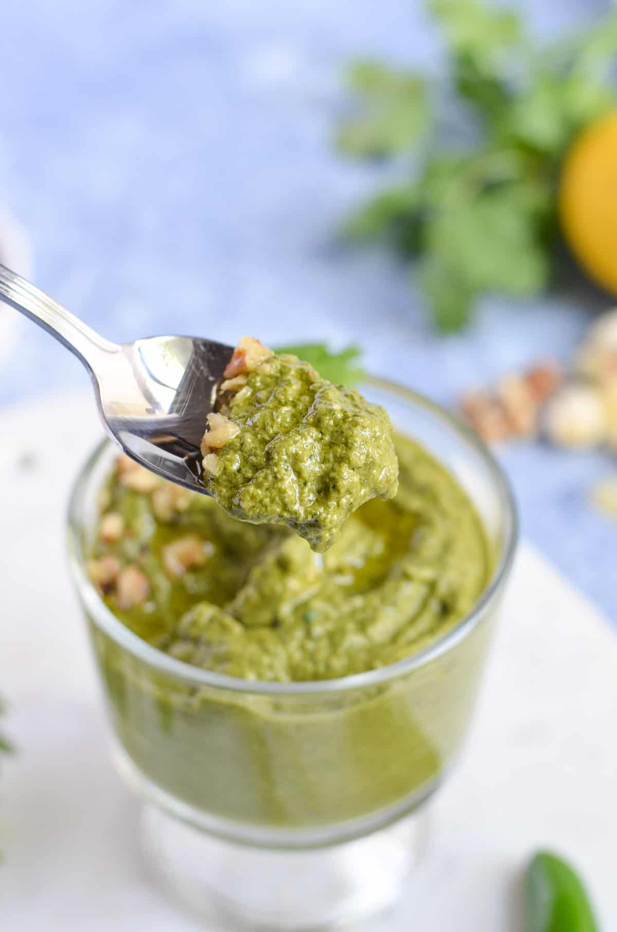 a close up click of pesto shown in a spoon.