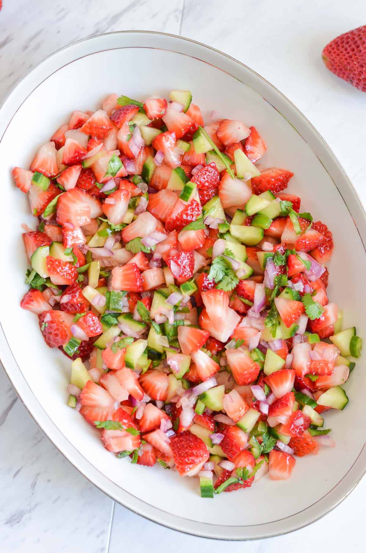 strawberry salsa with cucumber served in oval bowl