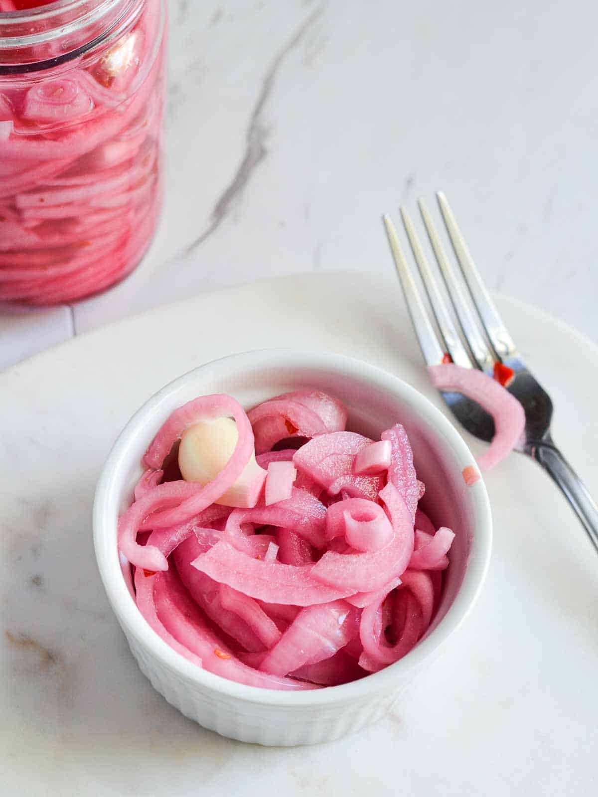 pickled onions in ramekins and fork on its side