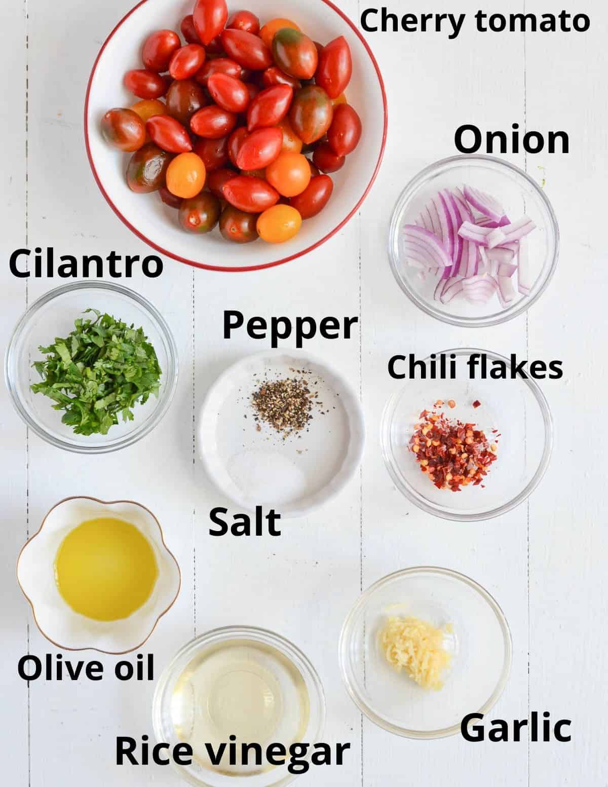 all the ingredients listed to make the dressing & tomato salad on the white board.