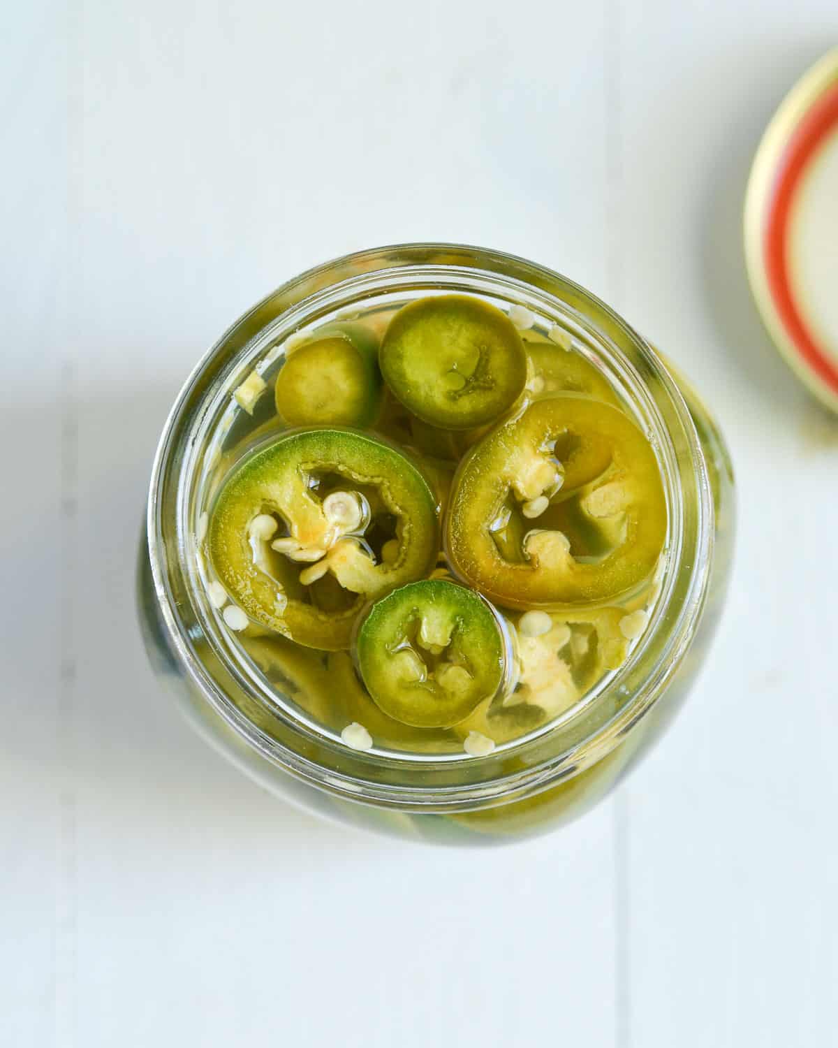 overhead click of the jar filled with pickled jalapeno rings.
