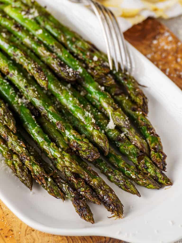 Close-up of grilled asparagus spears with crispy tips, lightly charred and sprinkled with coarse salt.